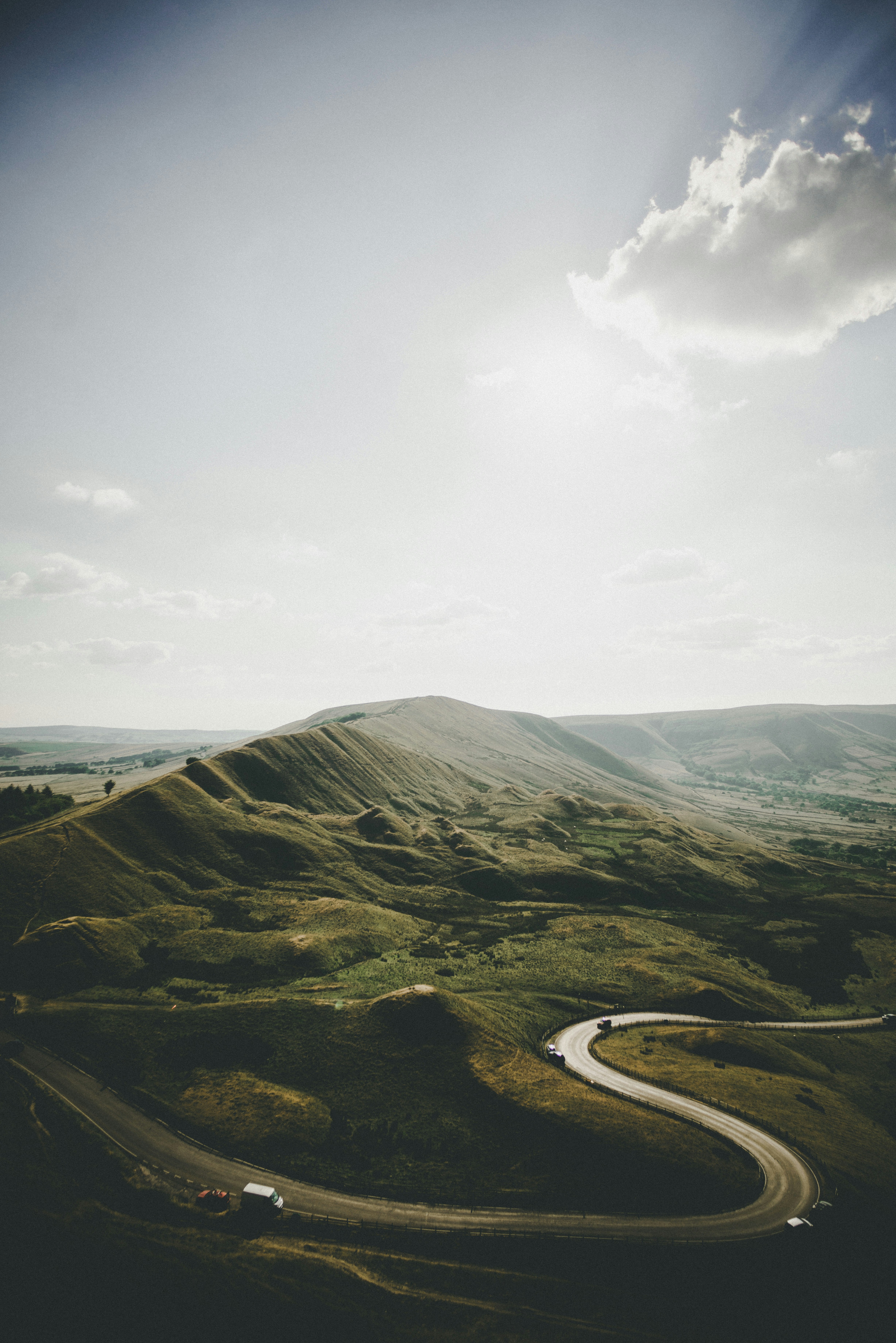 A single road winding through open moorland in the Peak District